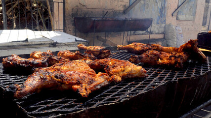 Close up shot of a jerk chicken on the grill. Caribbean street food.