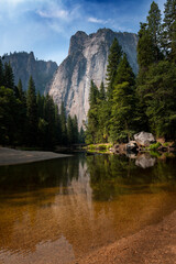 Scenic view of the merced river in the Yosemite valley, with the rocky mountains reflected on the...