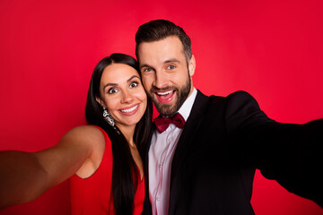 Photo of cheerful handsome guy attractive lady make selfie have fun isolated on red color background