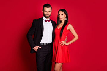 Photo of pretty optimistic couple hug wear suit dress isolated on red color background