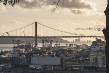 Obraz premium Ponte 25 de Abril with industry zone of Lisbon in forefront. Most famous bridge in Portugal. Lisbon. Red bridge.