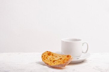 White ceramic cup with coffee and crackers on a white background. With copy space.