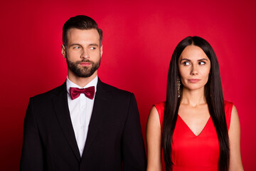 Portrait of pretty couple look each other wear suit dress isolated on red color background