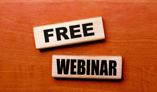 On a wooden table are two wooden blocks with the text FREE WEBINAR