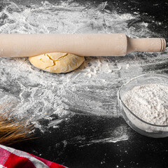 Ingredients for cooking pizzas lie on a black table. dough, eggs, ears