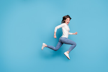 Fototapeta na wymiar Full length photo of funny adoranle wavy lady wear white sweater jumping running isolated blue color background