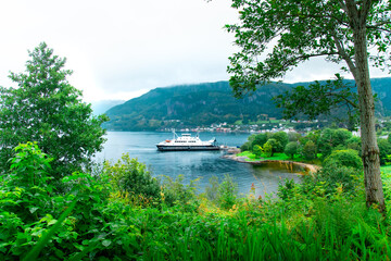 Norwegian landscape. Beautiful fjords. Cloudy and rainy day. Lakes and mountains. Boat and ferry