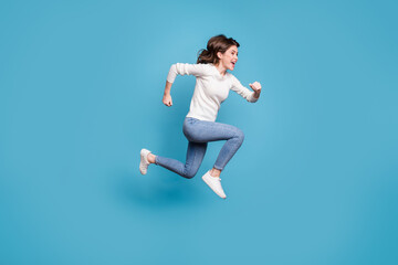Fototapeta na wymiar Full length photo of sweet adorable curly woman dressed white pullover jumping hands arms fists isolated blue color background