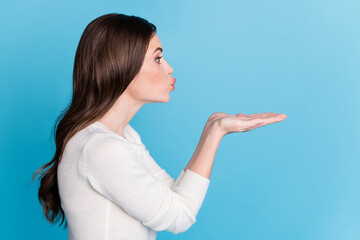 Photo of adorable sweet curly woman dressed white pullover rising palms sending kiss empty space...