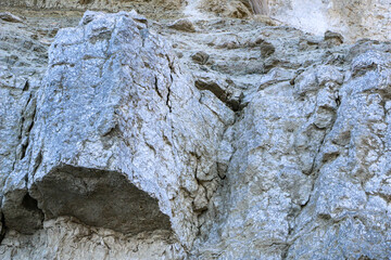 sandy-gypsum cut of the earth in quarry for the extraction of gypsum. Mountain textures of different soil layers with deposits of sand, clay, gypsum, quartz and gypsum ore, after erosion.
