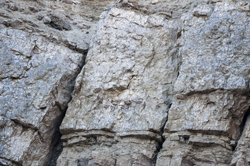 sandy-gypsum cut of the earth in quarry for the extraction of gypsum. Mountain textures of different soil layers with deposits of sand, clay, gypsum, quartz and gypsum ore, after erosion.