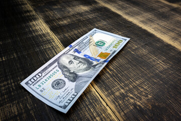 textured background of one hundred dollar bill with a portrait of us President Franklin in orange, red and black colors. blur, defocus.