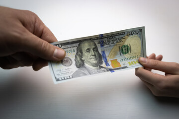 textured background of one hundred dollar bill with a portrait of us President Franklin in orange, red and black colors. blur, defocus.