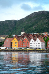 Fototapeta na wymiar Bergen in Norway. View of historical colorful buildings in Bryggen. Colorful historic houses situated in the harbor. Mountains in the background. UNESCO World Heritage Site 