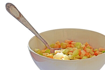 A bowl of celery and Apple salad and a tablespoon on a white background close up