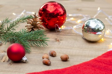 Beautiful red Christmas balls on wooden background. Christmas background with nuts, pine cone,...