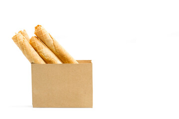 Waffle roll, rollos de galleta dentro de una bolsa de papel marrón sobre fondo blanco liso y aislado. Vista de frente y de cerca. Copy space
