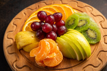 assorted fruit plate on dark background