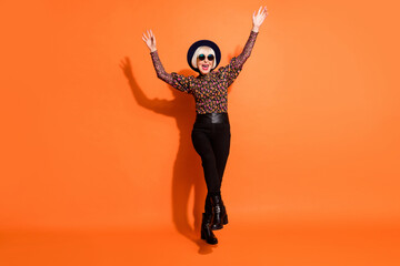 Fototapeta na wymiar Full size photo of smiling cheerful crazy funky grandmother dancing feel young isolated on orange color background