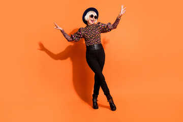 Full size photo of funky positive crazy happy grandmother dancing feeling young isolated on orange color background