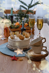 Christmas and celebration with tangerines, champagne and homemade cake. New Year holiday decorated table