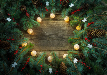 Christmas wreath on wooden background. Christmas fir tree branches background. Round christmas...