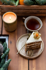 Christmas ornaments, candle, hot punch in ceramic mug and slice of sweet carrot cake. Cozy place on the loggia. Scandinavian mood