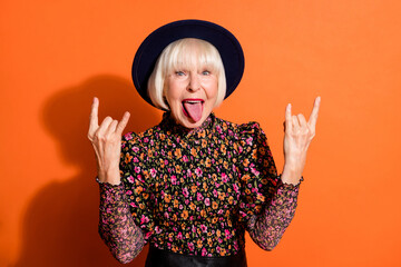 Photo portrait of crazy mad grandmother showing tongue heavy metal horns gesture isolated on vivid...