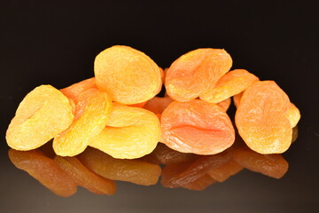 Bright golden organic dried apricots, close-up, isolated on black.
