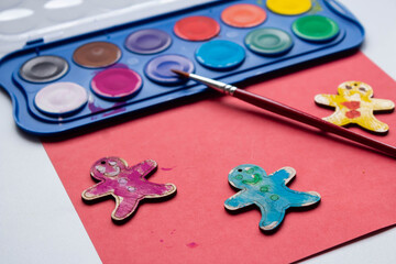 gingerbread man made of wood paint and a brush are on the table