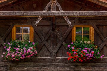 Fototapeta na wymiar house in the mountains with flowers at the window