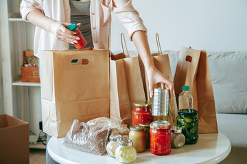 Woman packing food for donation in paper bag
