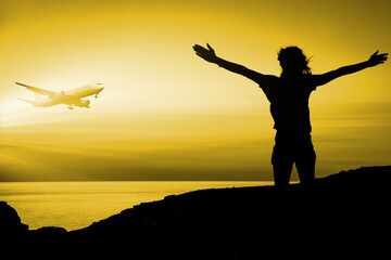 Fototapeta na wymiar Woman on the island waving her arms to flying plane during sunset