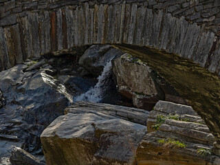 Rocks under the arch of the stone bridge