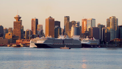 Fototapeta premium Vancouver, BC, Canada: Skyline of the downtown with the cruise ships docked in the early morning. Golden hour.