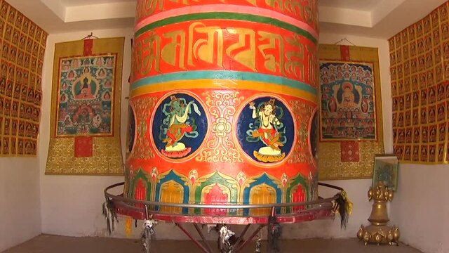 Huge rolling prayer wheel with mantra sounds "Om mani padme hum", literally means 'Oh, jewel in the lotus' but has much more deeply spiritual meanings. Tibetan plateau, Qinghai province, China.
