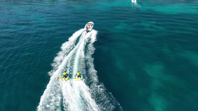 Aerial drone video of extreme powerboat donut watersports cruising in high speed in tropical emerald sea bay