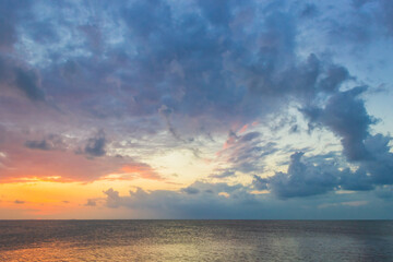 sunset over the sea in the evening with colorful sunlight dark clouds 