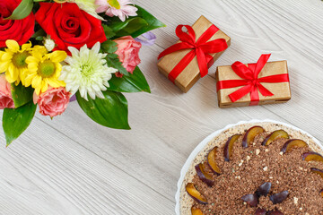 Fototapeta na wymiar Chocolate cake decorated with plums and flowers