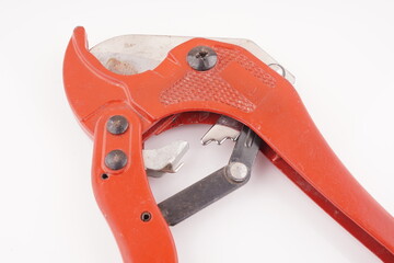 red knife for plastic pipes on a white background