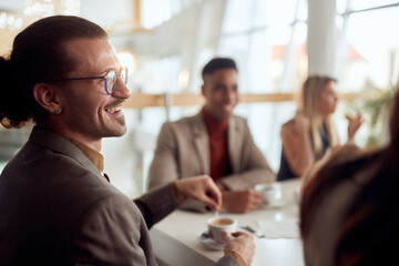 A young employee enjoying a coffee with colleagues at company's canteen. People, job, company, business concept.