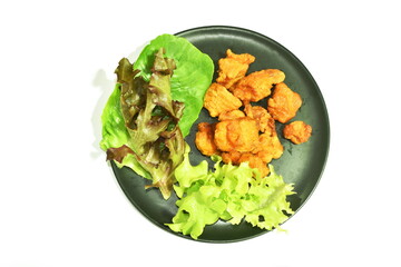 spicy fried soft chicken meat with vegetable salad on plate
