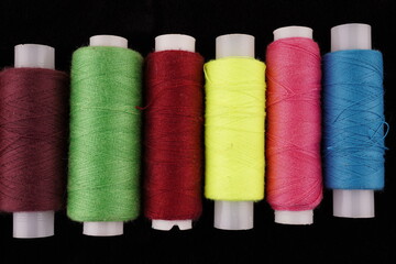 colored threads on a black background