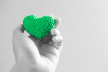 Hand holding green heart. selective focus