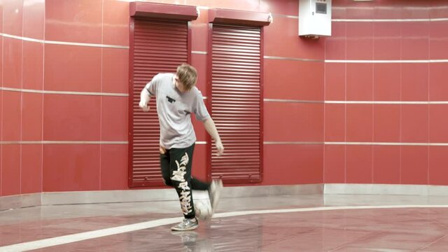 Football freestyle. Teenager guy football soccer player practicing tricks, kicks and moves with ball. Professional football freestyler athlete stuffing kicking the ball and making cool tricks 