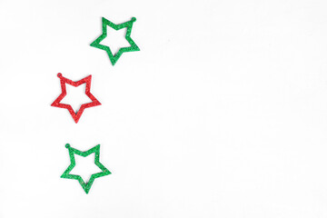Obraz premium Three glittering star shaped decorations against the white background. Copy space. Minimalist festive background