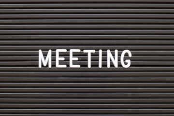 White alphabet in word meeting on black color felt letter board background