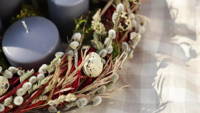 candles in Easter wreath with willow branches in a basket