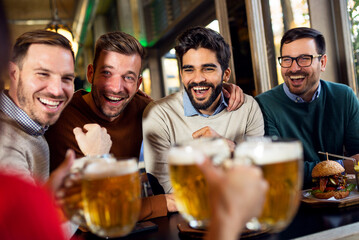 Group of four friends enjoying in beer pub