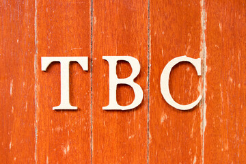 Alphabet letter in word  TBC (Abbreviation of to be confirmed or continued) on old red color wood...
